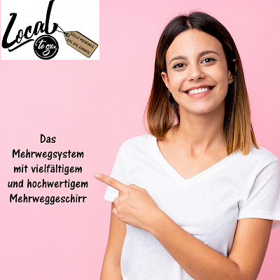 Eine Frau lächelt in die Kamera und zeigt auf einen Spruch.